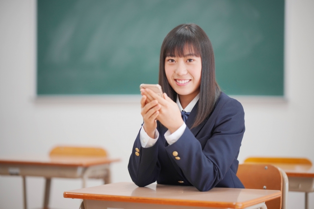 スマホを見る女子高校生